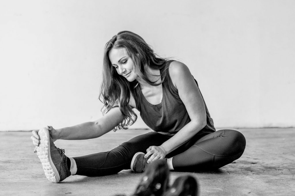 woman stretching legs as a warm-up exercise